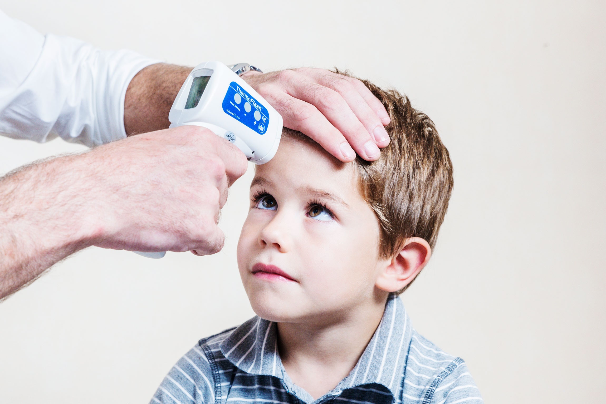 a doctor taking a boy temperture